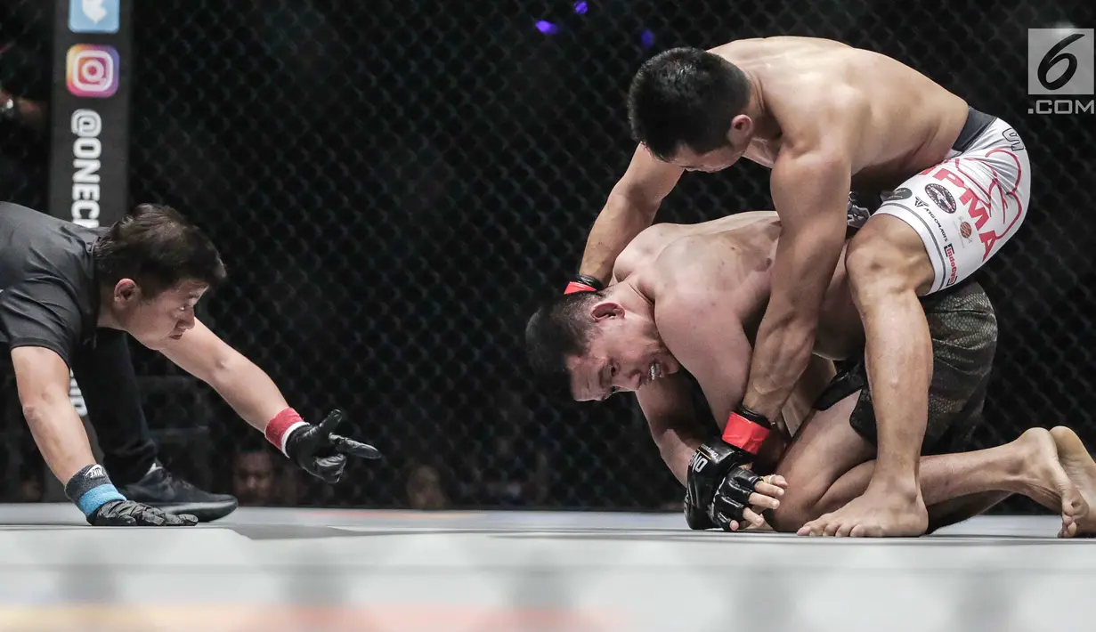 Dua petarung Indonesia Victorio Senduk (kiri) berusaha mengunci gerak Yohan Mulia Legowo (bawah) saat berlaga pada One Championship di Jakarta, Sabtu (20/1). Pada laga tersebut Victorio Senduk menang atas Yohan Mulia. (Liputan6.com/Faizal Fanani)