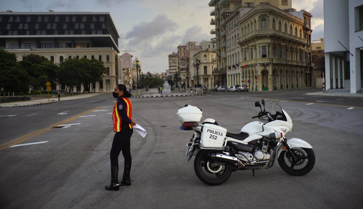 Polisi yang mengenakan masker berjaga di jalanan saat penerapan jam malam di Havana, Kuba, Selasa (1/9/2020). Otoritas Kuba menerapkan lockdown selama 15 hari di Havana untuk keluar dari penularan COVID-19 tingkat rendah tetapi terus-menerus. (AP Photo/Ramon Espinosa)