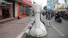 Warga berjalan kaki di samping barrier atau penghalang di kawasan Harmoni, Jakarta, Kamis (27/10/2022). Barrier yang biasa digunakan ketika terjadi demonstrasi Itu menyulitkan pejalan kaki saat melintas di trotoar. (Liputan6.com/Faizal Fanani)