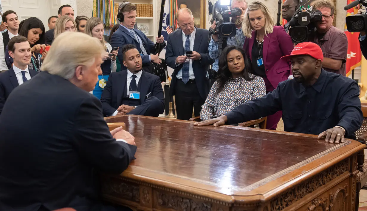 Presiden AS, Donald Trump bertemu dengan rapper Kanye West di Oval Office, Gedung Putih, Kamis (11/10). Suami Kim Kardashian itu ditemani menantu Trump sekaligus penasihat senior sang presiden, Jared Kushner. (SAUL LOEB / AFP)