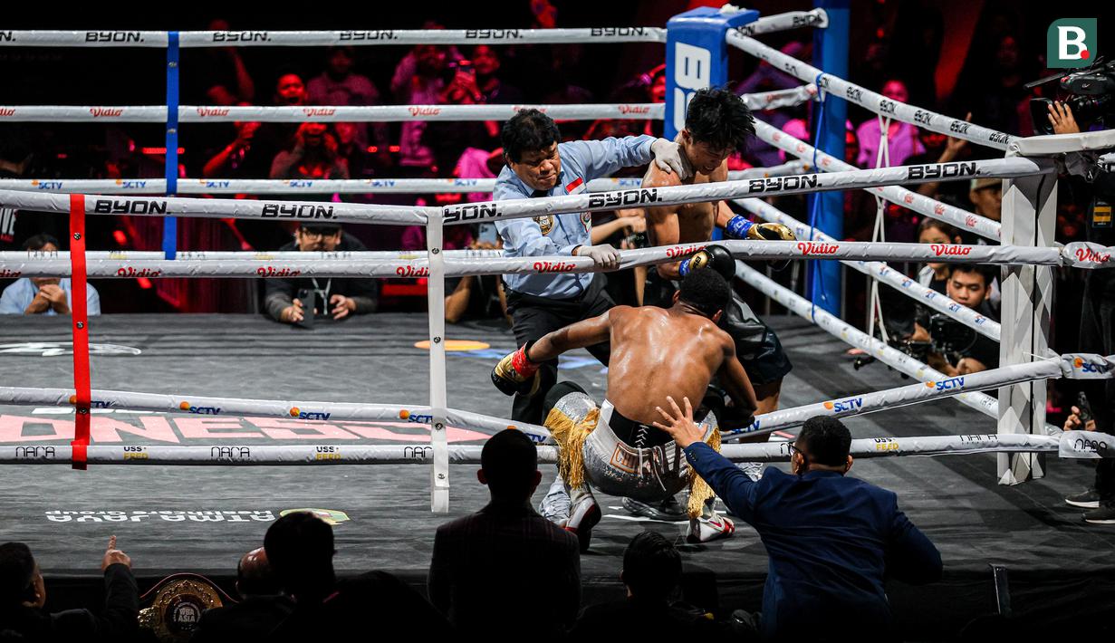 Ida Bagus Dwija Maha Gangga (Ibas) (kanan) melakukan pukulan knock out kepada Atevus Chima Okefielem (Chima) (tengah) dalam pertarungan debut tinju profesional Byon Madness di Studio 6 Emtek City, Daan Mogot, Jakarta, pada Sabtu (26/04/2025). (Bola.com/Bagaskara Lazuardi)