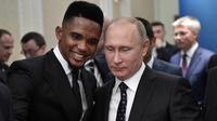 Presiden Rusia Vladimir Putin (kanan) berfoto bersama bintang sepak bola Kamerun, Samuel Eto'o saat menghadiri undian Piala Dunia 2018 di Moskow, Rusia (1/12). (Alexei Nikolsky, Sputnik, Kremlin Pool Photo via AP)