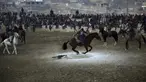 Penunggang kuda berebut kambing pada pertandingan persahabatan buzkashi di pinggiran Kabul, Afghanistan, Jumat (27/12/2019). Buzkashi adalah olahraga tradisional Afghanistan di mana para pemainnya berlomba untuk menempatkan bangkai kambing ke dalam lingkaran. (AP Photo/Rahmat Gul)
