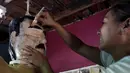 Pekerja mengecat alis saat menyelesaikan boneka raja narkoba Joaquin "El Chapo" Guzman di Reynosa, Meksiko (21/7/2015). Guzman melarikan diri dari penjara melalui terowongan yang ia buat pada bulan lalu. (REUTERS/Daniel Becerril)