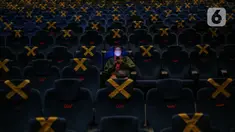 Penonton duduk dengan menjaga jarak di dalam bisokop CGV Grand Indonesia, Jakarta, Kamis (16/9/2021). Pemerintah memberikan kelonggaran dengan memperbolehkan bioskop buka kembali di wilayah berstatus PPKM level 3 dan 2 dengan kapasitas pengunjung 50 persen. (Liputan6.com/Faizal Fanani)