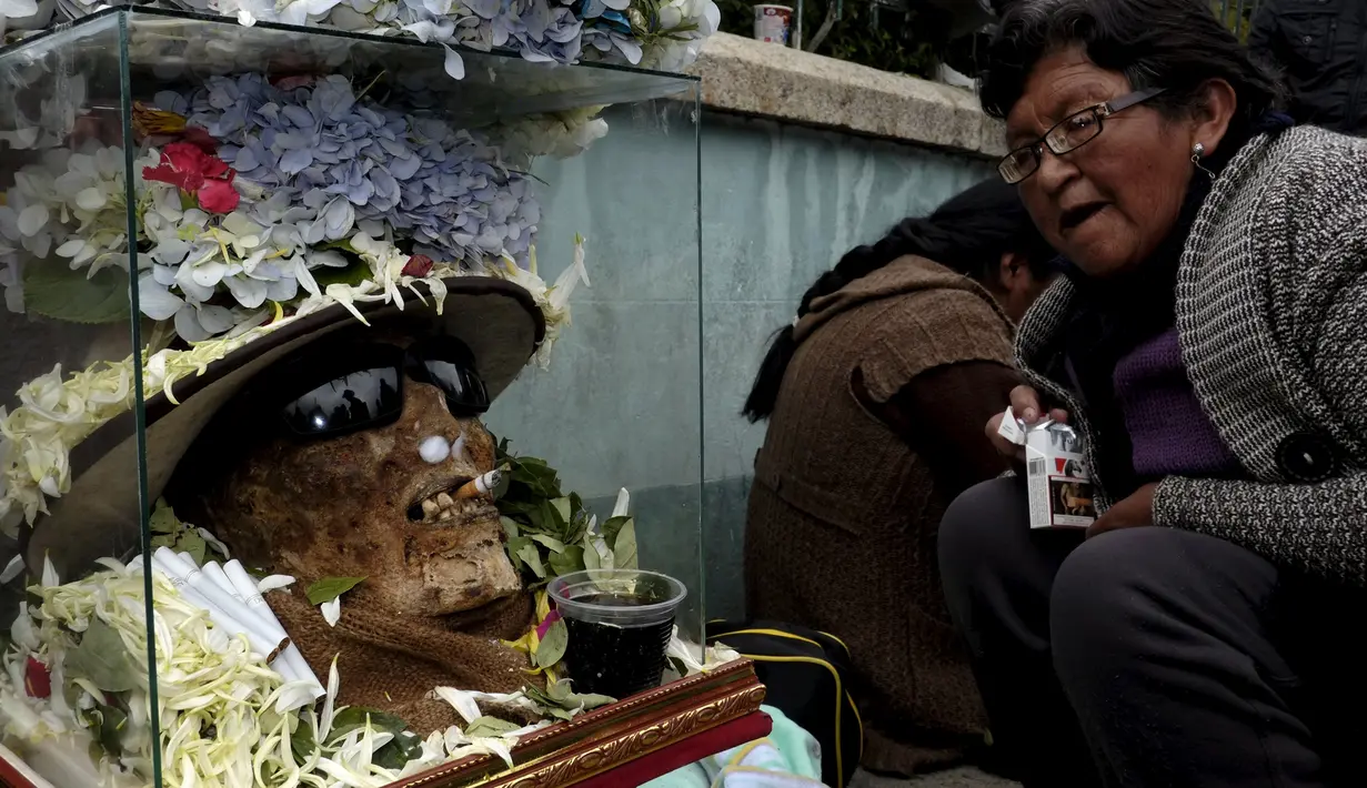 Tengkorak dengan putung rokok dimulutnya terlihat saat upacara hari tengkorak di pemakaman Umum La Paz, Bolivia, (8/11/2015).  Tiap tahun mereka berkumpul di pemakamaan untuk melakukan ritual mendoakan leluhur  mereka. (REUTERS/David Mercado)