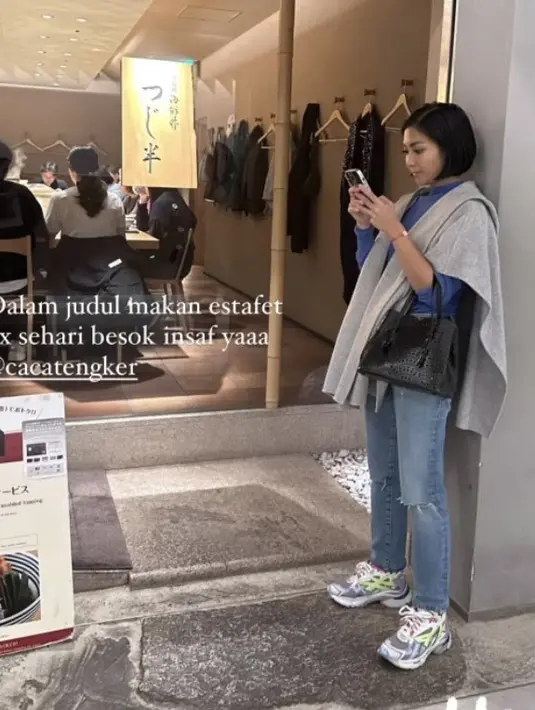 Difoto candid, Caca nampak simple mengenakan hoodie biru dipadukan outer abu-abu dan celana denimnya. @tashyanaraysha