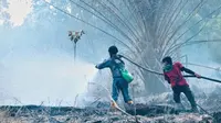 Petugas memadamkan kebakaran lahan di Suaka Margasatwa Giam Siak Kecil yang disengaja dibakar untuk pembukaan kebun. (Liputan6.com/Dok BBKSDA Riau)