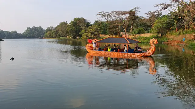 Anggota KNKT meninjau lokasi helikopter yang jatuh di Danau Bupetra, Kecamatan Cimanggis, Kota Depok, gunakan perahu naga. (Liputan6.com/Dicky Agung Prihanto)