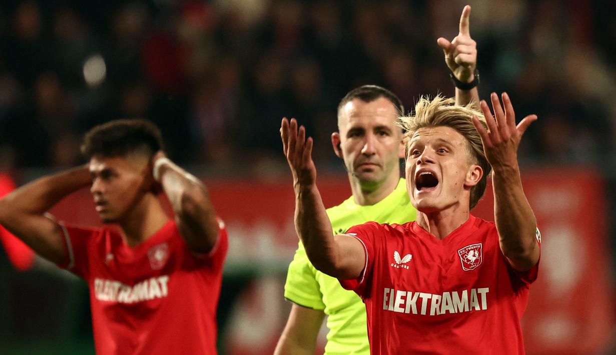 Pemain FC Twente, Sem Steijn bereaksi oleh keputusan wasit saat laga Liga Europa 2024/2025 melawan Fenerbahce di FC Twente stadium, Enschede, Belanda, Jumat (04/10/2024) dini hari WIB. (AFP/Vincent Jannink)