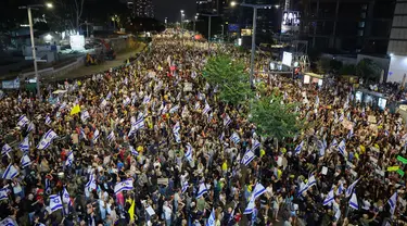 Para pengunjuk rasa mengangkat bendera dan plakat dalam unjuk rasa anti-pemerintah yang menuntut pembebasan warga Israel yang disandera oleh militan Palestina di Gaza sejak Oktober, di depan Kementerian Pertahanan Israel di Tel Aviv pada 14 September 2024. (Jack GUEZ/AFP)