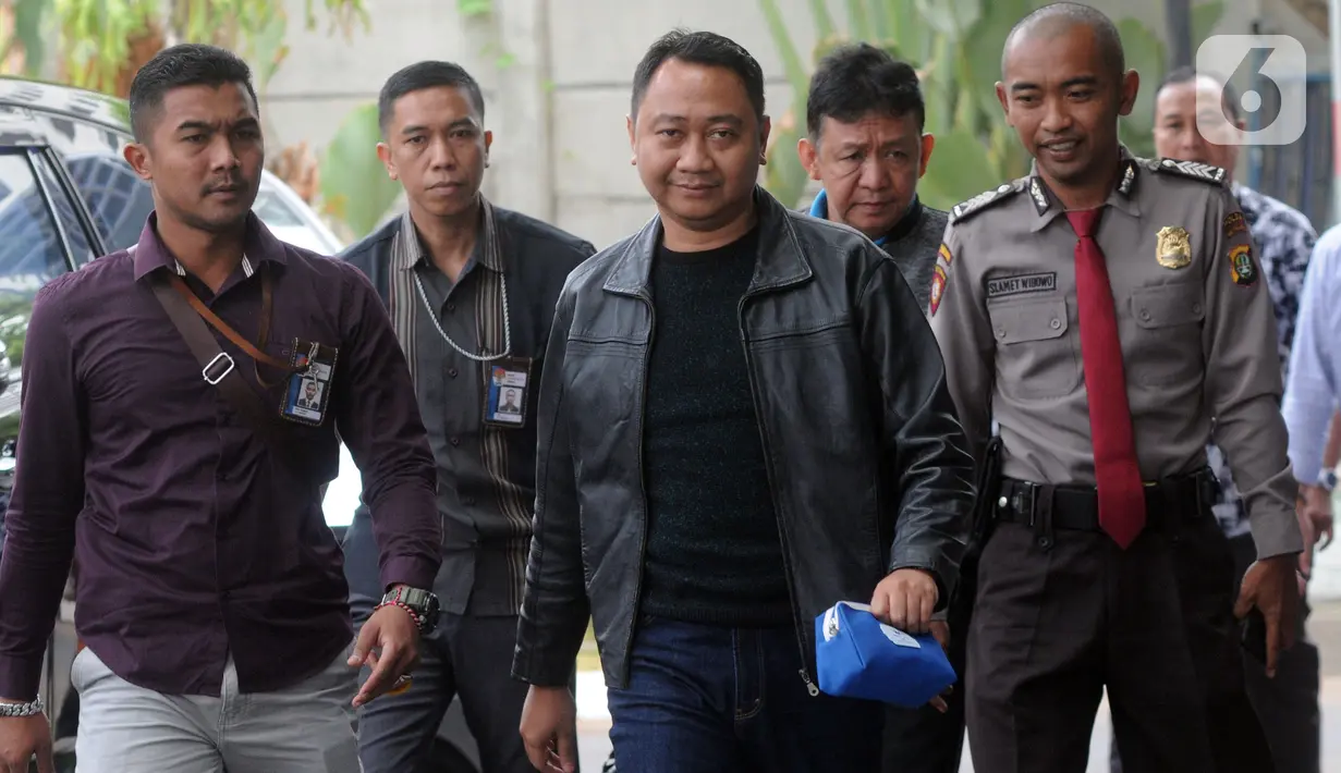 Bupati Lampung Utara Agung Ilmu Mangkunegara (tengah) dikawal petugas setibanya di Gedung KPK, Jakarta, Senin (7/10/2019). KPK mengamankan Agung dan enam orang lainnya berikut uang Rp 600 juta setelah terjaring operasi tangkap tangan (OTT) pada Minggu (6/10) malam. (merdeka.com/Dwi Narwoko)