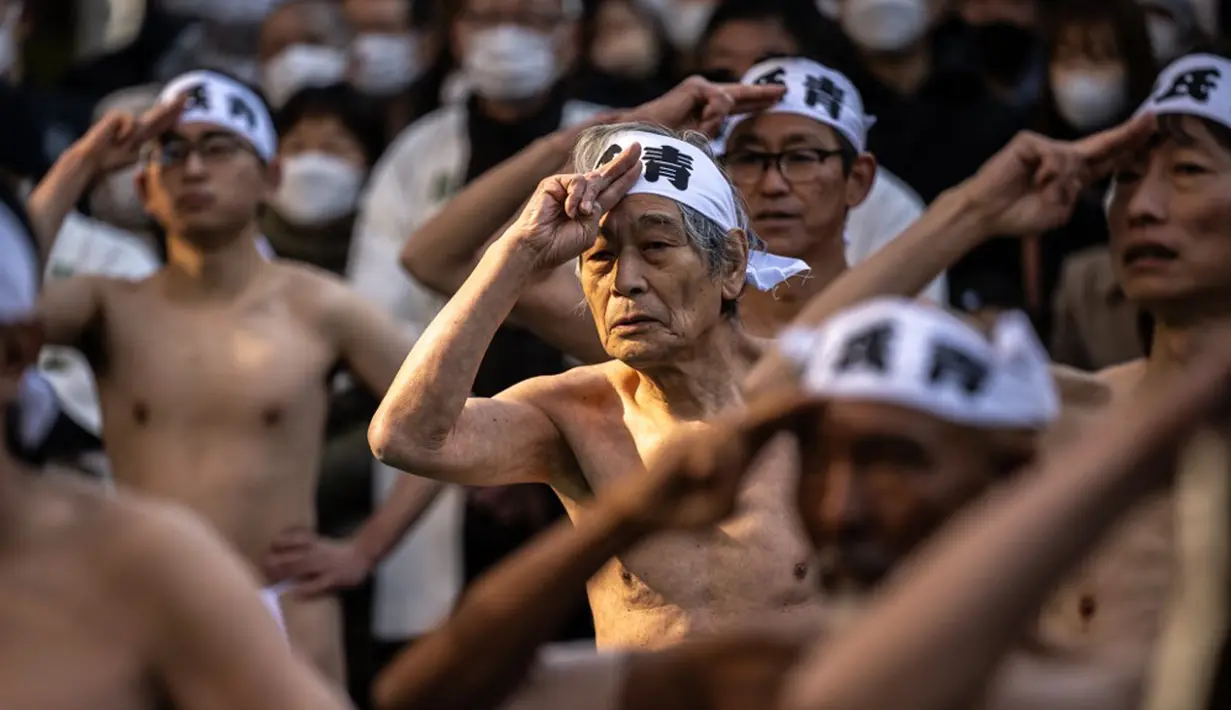 Penganut Shinto melakukan pemanasan sebelum mandi dengan air dingin di Kuil Teppozu Inari, Tokyo, Jepang, 8 Januari 2023. Ritual Tahun Baru ini dilakukan untuk memurnikan jiwa dan raga. (Philip FONG/AFP)