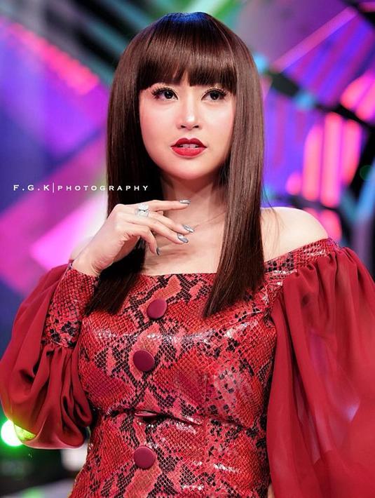 Pelantun lagu Halalin Aku itu tak pernah gagal untuk memesona dengan pilihan busana serta model rambutnya. Depe bereksperimen dengan model rambut nyentrik ala Cleopatra berupa poni dan rambut lurusnya. Depe juga mengenakan busana bermotif sisik ular berwarna merah. (Liputan6.com/IG/@dewiperssikreal)