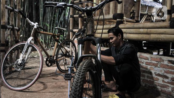 Perajin menyelesaikan perakitan sepeda bambu Jatnika di Workshop Perajin Bambu Indonesia, Cibinong, Bogor, Jawa Barat, Minggu (5/7/2020). Harga sepeda bambu Jatnika tergantung jenis serta tingkat kerumitan pembuatan. (merdeka.com/Iqbal S. Nugroho)