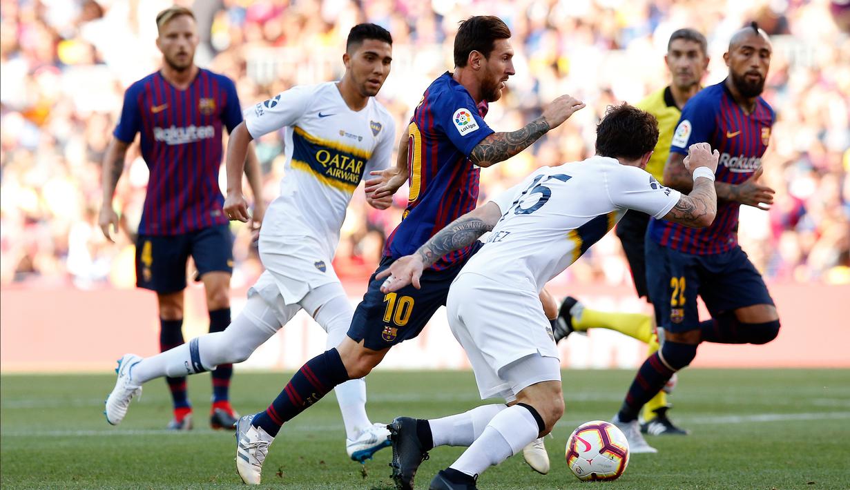 Penyerang Barcelona, Lionel Messi menggiring bola dari kejaran pemain Boca Juniors selama pertandingan Piala Joan Gamper di stadion Camp Nou, Spanyol (15/8). Barcelona menang telak 3-0 atas Boca Juniors. (AP Photo/Manu Fernandez)