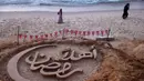 Kegiatan menjadi upaya menghadirkan keceriaan dan nuansa perayaan Ramadan di tengah kehancuran akibat konflik. Tampak dalam foto, orang-orang berjalan melewati patung pasir dengan pesan ucapan "Selamat Datang, Ramadan" yang dibuat oleh seniman Palestina, Yazeed Abu Jarad, di sepanjang pantai di Khan Younis, selatan Gaza pada 17 Februari 2026. (Bashar Taleb/AFP)