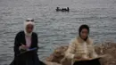 Lokakarya ini merupakan sebuah inisiatif terapi seni pemulihan (healing art) yang ditujukan bagi anak muda dan perempuan di Jalur Gaza. Tampak dalam foto, para perempuan muda melukis berlatar seorang pria yang mengemudikan perahu di pelabuhan Kota Gaza pada Kamis 12 Februari 2026. (Omar AL-QATTAA/AFP)
