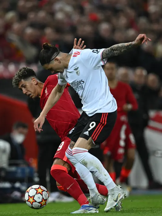 Penyerang Benfica, Darwin Nunez (kanan) berebut bola dengan penyerang Liverpool, Roberto Firmino dalam pertandingan leg kedua perempat final Liga Champions di stadion Anfield, di Liverpool, pada 13 April 2022. (AFP/Paul Ellis)