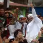 Rizieq Shihab menyapa massa pendukungnya saat tiba di kediamannya di Jalan Petamburan, Jakarta, Selasa (10/11/2020). Rizieq Shihab tiba di kediamannya usai pulang dari Arab Saudi. (merdeka.com/Imam Buhori)