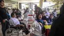 Penyelenggara berharap bursa kerja ini mampu menjangkau sekitar 7.000 penyandang disabilitas. Tampak dalam foto, para penyandang disabilitas menunggu untuk menyerahkan formulir lamaran mereka dalam bursa kerja yang diselenggarakan pemerintah daerah di Surabaya, Jawa Timur, pada Selasa 25 November 2025. (JUNI KRISWANTO/AFP)