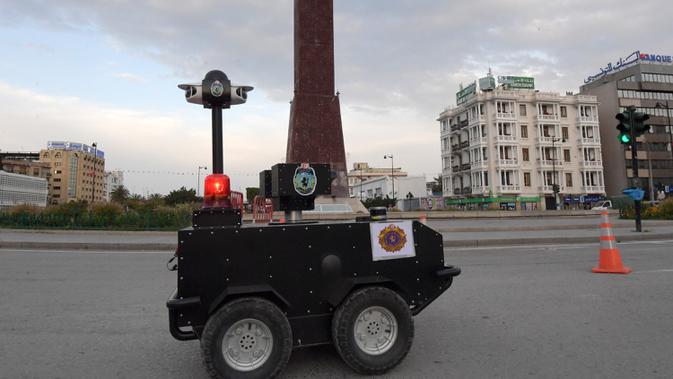 Sebuah robot polisi Tunisia berpatroli selama kebijakan penguncian (lockdown) di sepanjang Avenue Habib Bourguiba, pusat ibu kota Tunis, Rabu (1/4/2020). Robot ini dilengkapi dengan deteksi termal (temperatur tubuh manusia) dan kemampuan video audio secara real time. (FETHI BELAID/AFP)