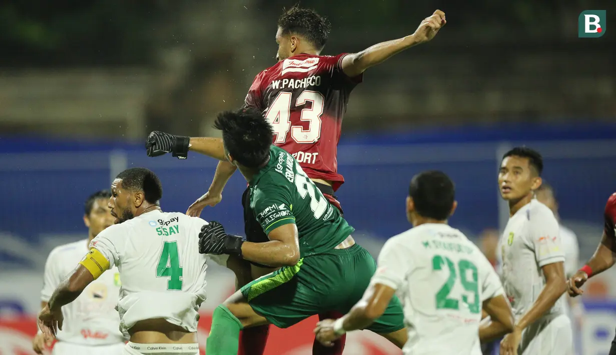 Kiper Persebaya Surabaya, Ernando Ari Sutaryadi, duel udara dengan bek Bali United, Willian Pacheco, pada pekan ke-33 BRI Liga 1 2021/2022 di Stadion I Gusti Ngurah Rai, Denpasar, Jumat (25/3/2022). (Bola.com/M Iqbal Ichsan)