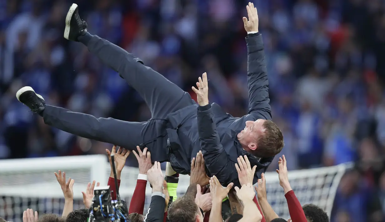 Pelatih Leicester City, Brendan Rodgers, diangkat para pemain saat selebrasi juara Piala FA di Stadion Wembley, Sabtu (15/5/2021). The Foxes menang dengan skor 1-0. (AP/Kirsty Wigglesworth, Pool)