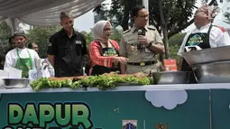 Gubernur DKI Jakarta Anies Baswedan didampingi istri Fery Farhati meninjau menu olahan daging kurban di Monas, Jakarta, Senin (12/8/2019). Sebanyak 5.000 boks makanan dari daging kurban dibagikan Pemprov DKI kepada warga Jakarta menengah ke bawah. (merdeka.com/Iqbal S. Nugroho)