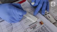 Tenaga medis melihat hasil rapid test massal yang digelar Badan Intelijen Negara (BIN) di lapangan Kecamatan Pamulang, Tangsel, Kamis (2/7/2020). Dengan adanya rapid test yang digelar BIN, Pemkot Tangsel dapat melakukan tracking dan tracing lebih cepat. (Liputan6.com/Fery Pradolo)