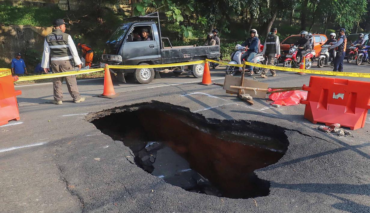 Pengendara melintas di sisi ruas jalan yang ditutup sebagian akibat amblas di Jalan Raya Lenteng Agung, Jakarta Selatan, Jumat (29/5/2026). (merdeka.com/Arie Basuki)