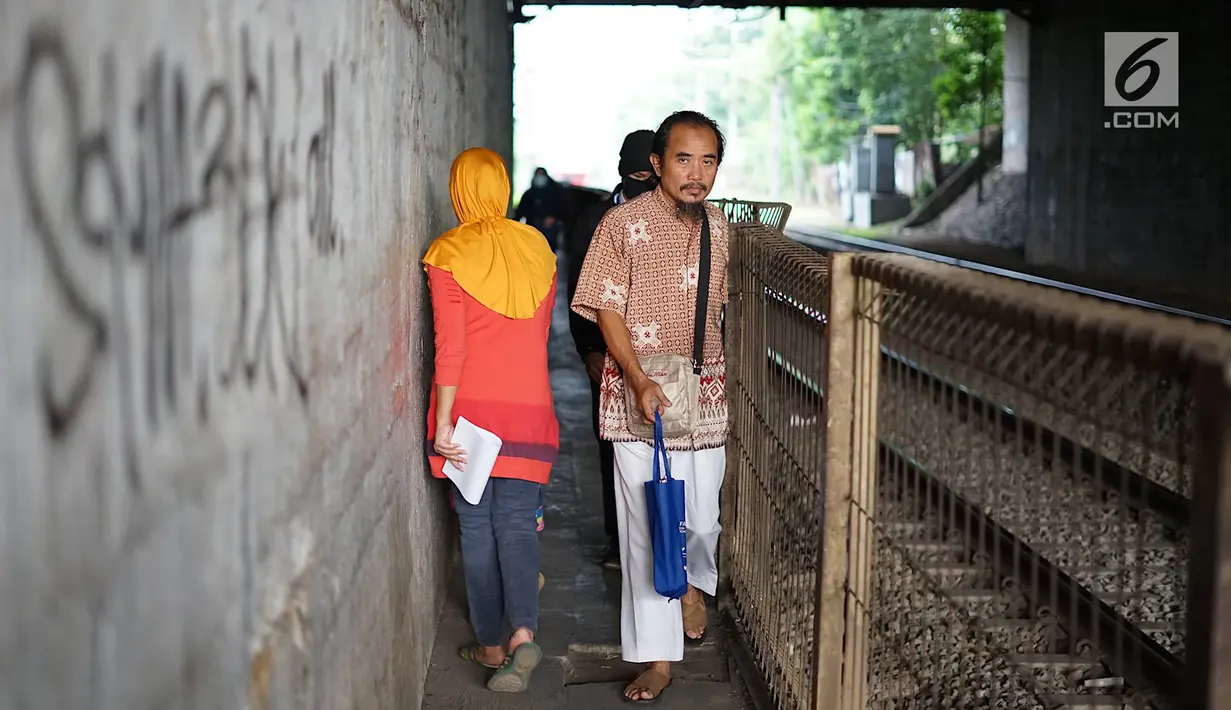 Pejalan kaki melintasi jalan setapak di sekitar Stasiun Cawang, Jakarta, Kamis (9/5). Meskipun sempit, jalan setapak tersebut masih menjadi pilihan sebagian pejalan kaki untuk menyeberangi Jalan Gatot Soebroto, dibanding harus melewati JPO yang jaraknya lebih jauh. (Liputan6.com/Immanuel Antonius)