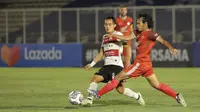 Pemain PSM Makassar, Rasyid Bakri (kanan) berebut bola dengan pemain Madura United, Slamet Nurcahyono (kiri) saat laga BRI Liga 1 2021/2022 antara Madura United melawan PSM Makassar di Stadion Madya, Jakarta, Minggu (12/9/2021). (Bola.com/Ikhwan Yanuar)