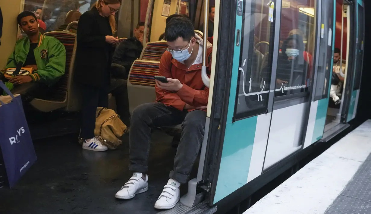Seorang pria yang mengenakan masker menaiki kereta bawah tanah di Paris, Prancis, Kamis (30/6/2022). Kasus virus corona covid-19 meningkat dengan cepat di Prancis dan negara-negara Eropa lainnya setelah pembatasan COVID-19 dicabut pada musim semi. (AP Photo/Michel Euler)