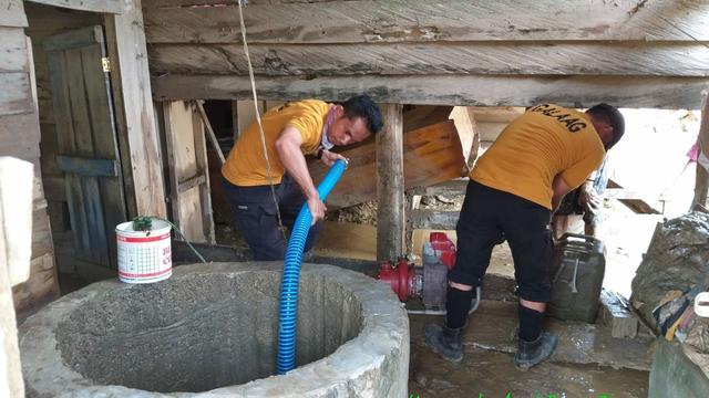 Tim Manggala Agni Sultra, menyedot sumur warga desa usai banjir, Rabu (19/6/2019).(Liputan6.com/Ahmad Akbar Fua)