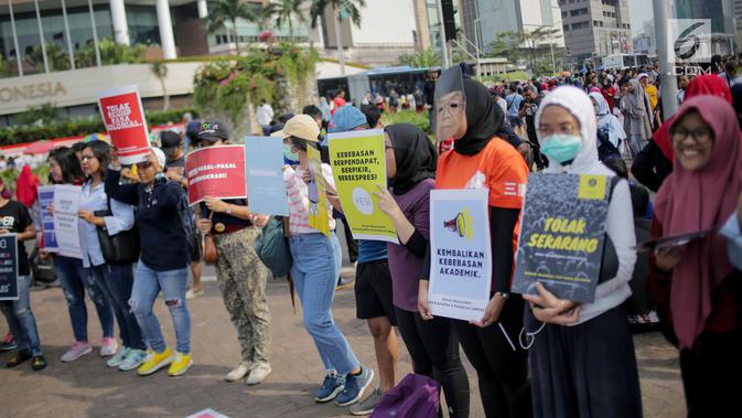 Massa yang tergabung dalam Aliansi Masyarakat Sipil untuk Keadilan dan Demokrasi menggelar aksi saat car free day (CFD) di kawasan Bundaran HI, Jakarta, Minggu (15/9/2019). Massa mengatakan RUU KUHP berpotensi digunakan untuk mengkriminalisasi korban kekerasan seksual. (Liputan6.com/Faizal Fanani)