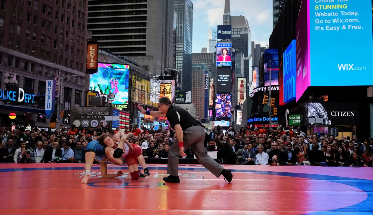 Wasit saat mengawasi pertandingan gulat antara Helen Maroulis (biru) dan Samantha Stewart dari Kanada pada kelas 53kg wanita di Times Square, New York (19/5). (REUTERS/Adrees Latif)