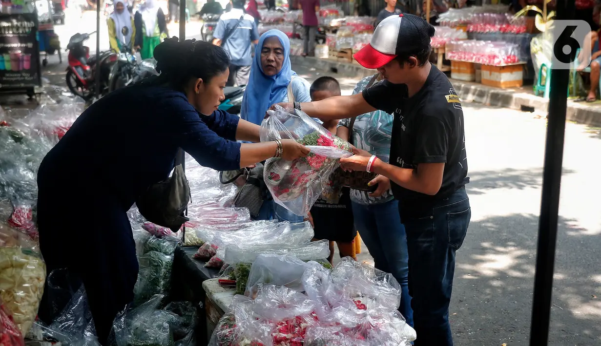 Pedagang melayani pembeli bunga tabur di pasar bunga Rawa Belong, Jakarta, Jumat (17/3/2023). (Liputan6.com/Angga Yuniar)