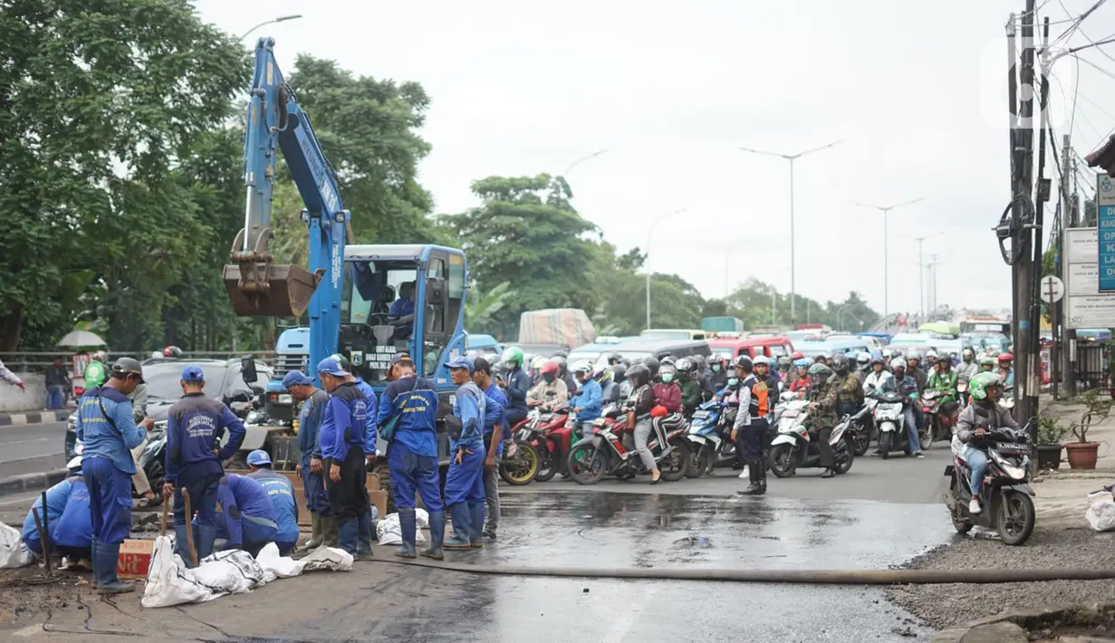 Petugas Sudin SDA Jakarta Timur dibantu alat berat membersihkan saluran gorong-gorong yang tertutup lumpur dan sampah di kawasan Pasar Rebo, Kamis (19/3/2020). Pembersihan untuk memperlancar sistem drainase yang tersumbat dan kerap menimbulkan genangan air. (Liputan6.com/Immanuel Antonius)