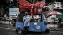 Karyo (61), sopir Bajaj berpose di kawasan Kramat Pulo, Senen, Jakarta Pusat, Selasa (22/6/2021). Di sisi lain, kehadiran Kampung Ondel-Ondel Kramat Pulo membawa rezeki baru bagi sopir angkot dan bajaj. (merdeka.com/Iqbal S. Nugroho)