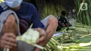 Pedagang membuat cangkang ketupat di kawasan Palmerah, Jakarta, Minggu (18/7/2021). Pemberlakuan PPKM Darurat membuat penjualan cangkang ketupat jelang Idul Adha tahun ini sepi pembeli. (Liputan6.com/Faizal Fanani)