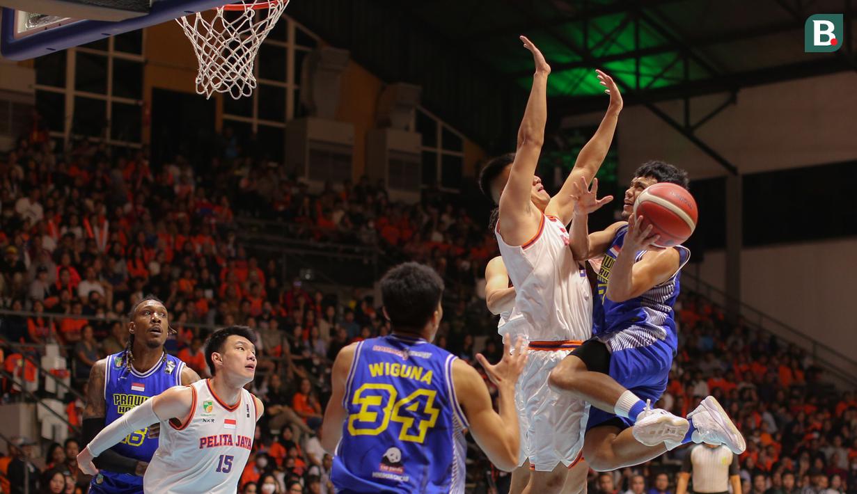 Pebasket Prawira Bandung, Yudha Saputera (kanan) berusaha memasukkan bola ke ring Pelita Jaya pada laga gim pertama final IBL 2023 di Hall Senayan, Jakarta, Kamis (20/07/2023). Laga dimenangkan oleh Prawira Bandung dengan skor 74-65. (Bola.com/Bagaskara Lazuardi)