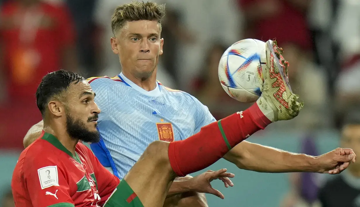 Penyerang Maroko Sofiane Boufal berebut bola dengan gelandang Spanyol Marcos Llorente pada babak 16 besar Piala Dunia 2022 di Education City Stadium, Al Rayyan, Rabu (6/12/2022) dini hari WIB. Maroko selanjutnya bertemu pemenang Portugal vs Swiss pada 8 besar. (AP Photo/Francisco Seco)