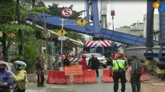 Posisi alat berat itu menimpa tembok pembatas di lantai tiga serta merusak sebuah rumah.
