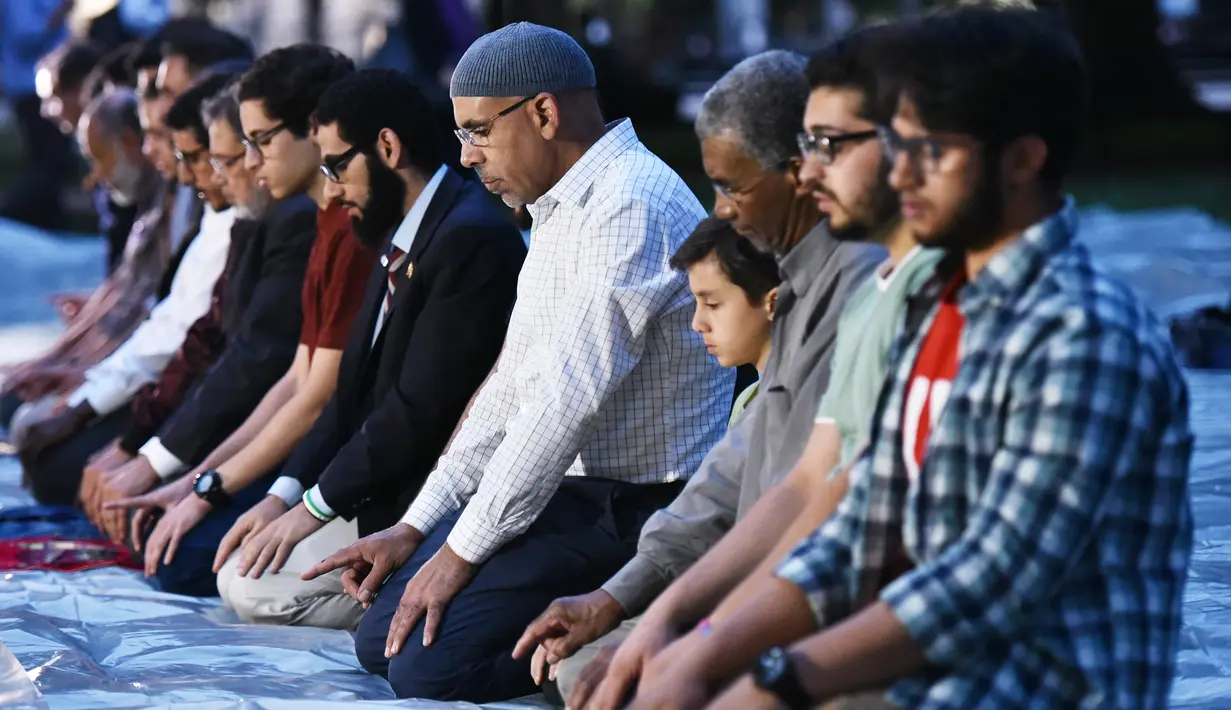Jemaah muslim pria melakukan salat sebelum berbuka puasa Ramadan di Lafayette Square, Washington DC (6/6). Acara ini juga bertepatan dengan buka puasa bersama yang diikuti Presiden AS, Donald Trump di Gedung Putih. (AFP/Mandel Ngan)