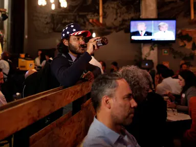 Seorang pendukung Partai Demokrat menyaksikan debat Capres AS Donald Trump dan Hillary Clinton dari siaran televisi di Sebuah Restoran di Meksiko, (19/10). Debat kali ini menjadi pertarungan terakhir keduanya jelang Pemilu di AS. (Reuters/Carlos Jasso) 