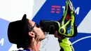 Valentino Rossi merayakan kemenangan dengan minum sampanye dari sepatunya saat berada di podium MotoGP San Marino di Sirkuit Misano, Minggu (11/9/2016). (AFP/Giuseppe Cacace))