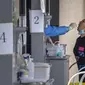 Pekerja menyeka tenggorokan seorang wanita di tempat pengujian virus corona COVID-19 pada hari ketiga tes massal untuk jutaan penduduk di Distrik Chaoyang, Beijing, China, 15 Juni 2022. (AP Photo/Mark Schiefelbein)