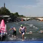 Para atlet berkompetisi di babak renang di Sungai Seine pada triathlon individu putra di Olimpiade Paris 2024 di pusat kota Paris pada 31 Juli 2024. (Anne-Christine POUJOULAT / AFP)