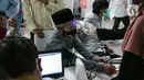 Petugas kesehatan memeriksa suhu tubuh seorang pemuka agama sebelum menjalani Vaksinasi COVID-19 di Mesjid Istiqlal, Jakarta, Selasa (23/2/2021). Pemuka agama yang mengikuti vaksinasi ini mencapai ribuan orang. (Liputan6.com/Faizal Fanani)